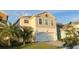 Two-story home with a large two-car garage, manicured lawn and paver driveway at 4571 Tribute Trl, Kissimmee, FL 34746