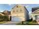 Two-story home with a two-car garage and a well-manicured lawn with paver driveway at 4571 Tribute Trl, Kissimmee, FL 34746