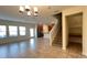 Open-concept living room featuring tile floors, abundant natural light, and access to the kitchen and staircase at 4571 Tribute Trl, Kissimmee, FL 34746