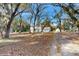 Traditional home featuring a long driveway lined with mature trees and a detached garage at 4855 Lillian Black Rd, St Cloud, FL 34771