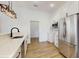 Updated kitchen featuring stainless steel appliances, a large sink, quartz counters, white cabinets, and wood-look floors at 4855 Lillian Black Rd, St Cloud, FL 34771