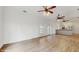 Bright living room open to the kitchen, featuring hardwood floors and a ceiling fan at 4855 Lillian Black Rd, St Cloud, FL 34771