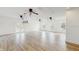 Spacious living room boasts wood look tile floors, ample natural light, ceiling fans, and white walls at 4855 Lillian Black Rd, St Cloud, FL 34771