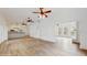 Open living room view showcasing hardwood floors, fans, a fireplace and connection to the kitchen and dining areas at 4855 Lillian Black Rd, St Cloud, FL 34771