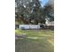 A spacious backyard with a large tree, and a white fence at 626 Baldwin Dr, Kissimmee, FL 34758