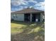 Backyard view of the house featuring a porch and lush grass at 626 Baldwin Dr, Kissimmee, FL 34758