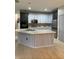 Modern kitchen with two-toned cabinets, a large island, and stainless steel appliances at 626 Baldwin Dr, Kissimmee, FL 34758