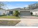 House exterior featuring a two-car garage and well-maintained landscaping at 6364 Domenico Ct, Groveland, FL 34736