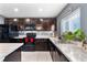 View of the kitchen's sink, countertops, and dark wood cabinetry at 6364 Domenico Ct, Groveland, FL 34736