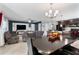 Living room with gray couches, a large TV, and access to kitchen area at 6364 Domenico Ct, Groveland, FL 34736