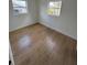 Bedroom features laminate floors, two windows offering plenty of natural light, and white walls at 701 N 4Th St, Haines City, FL 33844