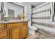 Bathroom with a wood cabinet vanity, square mirror, toilet, and striped shower curtain at 7933 Merrimac Cove Dr, Orlando, FL 32822