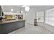 Bright kitchen with an island, modern lighting, white cabinets and tile floor at 7933 Merrimac Cove Dr, Orlando, FL 32822