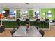Vibrant bar area with green accents, modern seating, and a fully stocked counter at 8939 Fallen Oak Dr, Davenport, FL 33896
