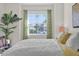 Bright bedroom featuring a ceiling fan, cozy carpet, and a large window with neighborhood views at 8939 Fallen Oak Dr, Davenport, FL 33896