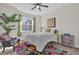 Bright bedroom featuring a ceiling fan, cozy carpet, and a large window with neighborhood views at 8939 Fallen Oak Dr, Davenport, FL 33896