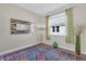 Bright bedroom featuring large windows with neutral colored walls and colorful rug at 8939 Fallen Oak Dr, Davenport, FL 33896