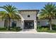 Exterior view of the clubhouse entrance framed by palm trees and manicured landscaping at 8939 Fallen Oak Dr, Davenport, FL 33896