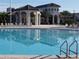 Large, pristine community pool with ample lounge seating and shade structures at 8939 Fallen Oak Dr, Davenport, FL 33896