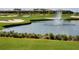 Scenic view of the golf course with sand traps, a water fountain, and luxury condos in the background at 8939 Fallen Oak Dr, Davenport, FL 33896