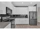 Modern kitchen with stainless steel appliances, white cabinets, and black subway tile backsplash at 8939 Fallen Oak Dr, Davenport, FL 33896