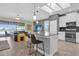 Open concept kitchen with modern island seating, stainless appliances, and a view of the living area at 8939 Fallen Oak Dr, Davenport, FL 33896