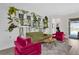 Bright living room featuring plant wall, colorful seating arrangement, and view through to covered patio at 8939 Fallen Oak Dr, Davenport, FL 33896