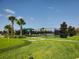 Pickleball court with green turf, surrounded by mature trees and manicured lawns in community at 8939 Fallen Oak Dr, Davenport, FL 33896