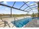 Gorgeous screened-in in-ground pool with water feature and view of the community at 8939 Fallen Oak Dr, Davenport, FL 33896