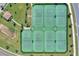 Aerial view of six well-maintained tennis courts in a community setting surrounded by lush landscaping at 8939 Fallen Oak Dr, Davenport, FL 33896