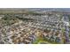 Expansive aerial view of a residential neighborhood with neatly arranged homes and community pond at 947 Emerald Green Ct, Kissimmee, FL 34746