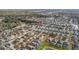 Expansive aerial view of a residential neighborhood with neatly arranged homes and community pond at 947 Emerald Green Ct, Kissimmee, FL 34746
