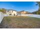 Large, green backyard with white fence and patio, offering ample space for entertainment at 947 Emerald Green Ct, Kissimmee, FL 34746