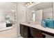 Bathroom vanity with dark wood cabinets, sink, and decorative vase next to the bedroom entrance at 947 Emerald Green Ct, Kissimmee, FL 34746