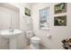 Half bathroom featuring a pedestal sink, toilet, and decorative butterfly artwork at 947 Emerald Green Ct, Kissimmee, FL 34746