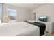 Bright bedroom featuring a plush bed, a dresser with TV, and a sunlit window with blinds at 947 Emerald Green Ct, Kissimmee, FL 34746
