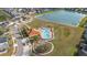 Aerial view of community pool and playground with mature landscaping near a pond at 947 Emerald Green Ct, Kissimmee, FL 34746