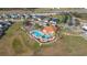 Aerial view of community pool and playground with mature landscaping and ample parking at 947 Emerald Green Ct, Kissimmee, FL 34746