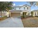 Two-story home with a two-car garage and a well-maintained lawn at 947 Emerald Green Ct, Kissimmee, FL 34746