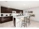 Modern kitchen features dark wood cabinets, white countertops, and stainless steel appliances at 947 Emerald Green Ct, Kissimmee, FL 34746