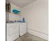 Bright laundry room includes a washer, a dryer and shelving at 947 Emerald Green Ct, Kissimmee, FL 34746