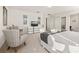 Airy primary bedroom featuring a bed, seating area, dresser with television, and art pieces at 947 Emerald Green Ct, Kissimmee, FL 34746