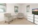 Well-lit bedroom with a seating area, artwork, and a dresser with a TV at 947 Emerald Green Ct, Kissimmee, FL 34746
