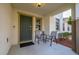 Cozy covered porch with seating, a small table, and a secure front door at 947 Emerald Green Ct, Kissimmee, FL 34746