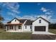 Beautiful farmhouse with a white facade, dark roof, and a front-facing garage at 0 Orangewood Ave, St Cloud, FL 34772