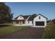 A farmhouse exterior with a driveway and a well-manicured lawn at 0 Orangewood Ave, St Cloud, FL 34772