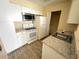 Kitchen with white cabinets, appliances, updated countertops, and modern flooring at 1091 S Hiawassee Rd # 216, Orlando, FL 32835