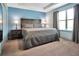 Comfortable bedroom features a tray ceiling, large window, and calming blue wall at 113 Kenny Blvd, Haines City, FL 33844