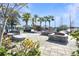 Relaxing community pool area featuring cozy lounge seating, lush greenery, and a tranquil lakeside view at 113 Kenny Blvd, Haines City, FL 33844