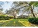 Large backyard with lush lawn, mature trees, and screened enclosure at 1145 Sugar Belt Dr, St Cloud, FL 34771